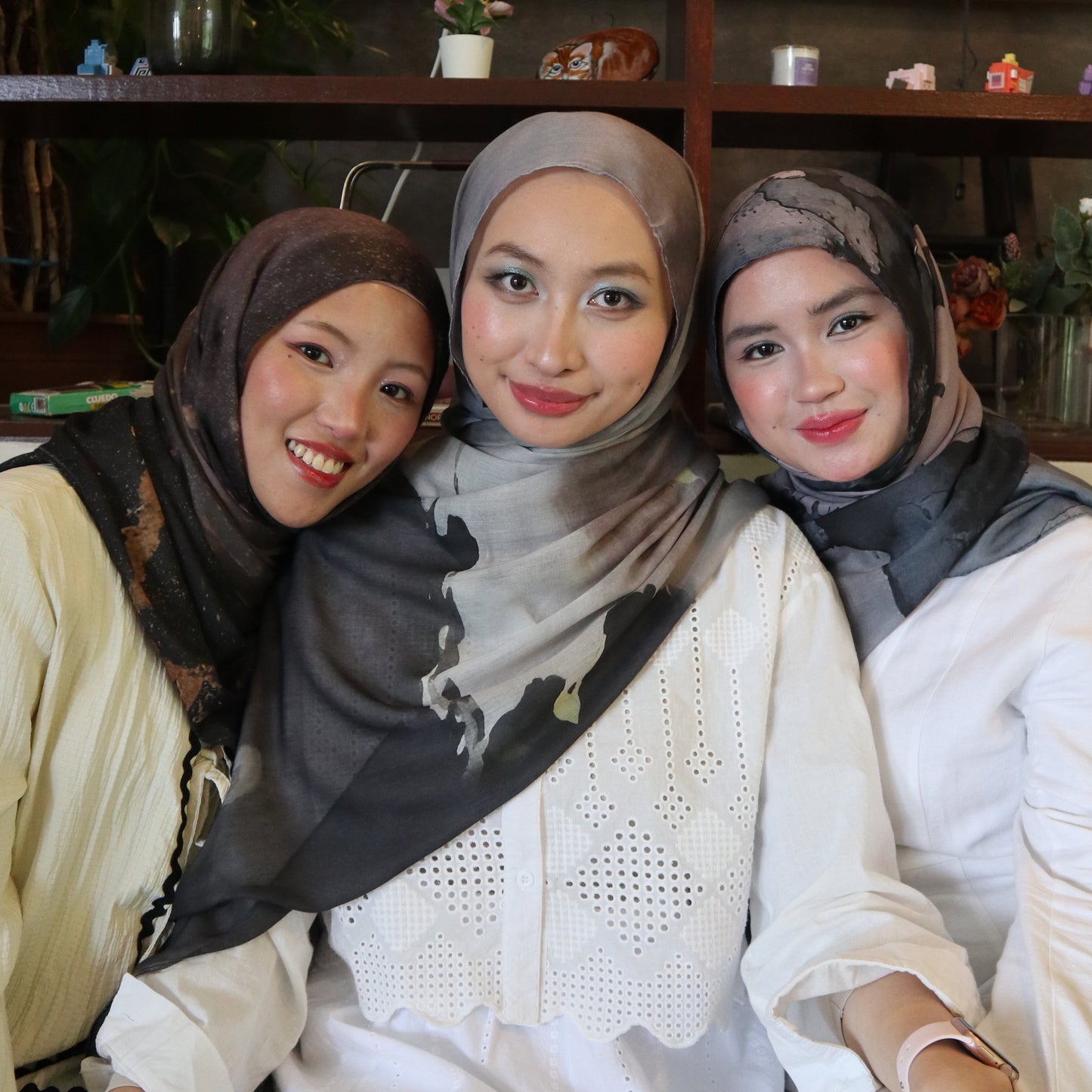 Three women wearing hijabs posing together in a store setting wearing Relilit Eco Concious Hijabs
